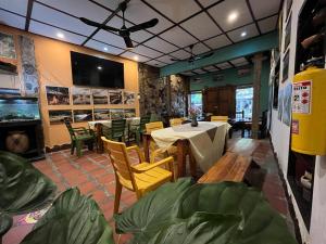 ein Esszimmer mit Tisch, Stühlen und Fernseher in der Unterkunft TONINAS Travel-Hotel in Inírida