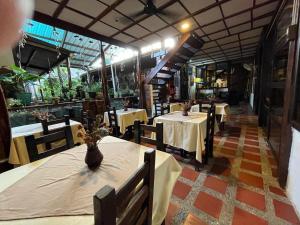 ein Restaurant mit Tischen und Stühlen und einer Vase auf dem Tisch in der Unterkunft TONINAS Travel-Hotel in Inírida