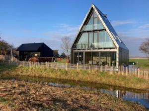 una casa con techo sobre un campo en Spoelde wiel, en Callantsoog