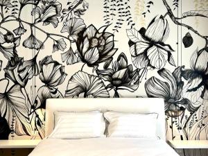 Un dormitorio con un mural de pared de flores en blanco y negro. en ARTinBòsc by Alterego, en Ferrere