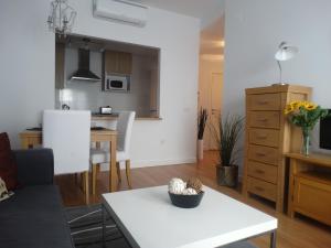 sala de estar con mesa blanca y cocina en Málaga Apartamentos - Montaño, 18, en Málaga