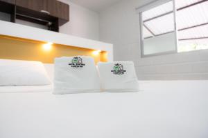 twee stapels handdoeken bovenop een bed bij Hotel Boutique Campestre in Florencia
