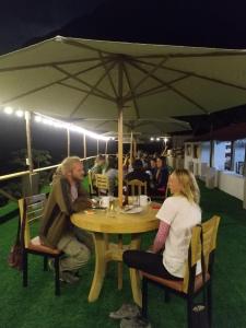 dwoje ludzi siedzących przy stole pod parasolką w obiekcie Eden Lodge w mieście Cabanaconde