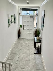 Un pasillo con una puerta blanca con una planta sobre una mesa. en Luxury House near China and Ocean Beach, en San Francisco
