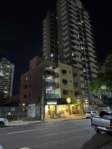 a tall building with a clock on the side of a street at Apartamentos Nadai 302 in Foz do Iguaçu