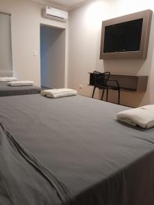 um quarto com 2 camas e uma televisão de ecrã plano em Hotel Azul Junin em Junín