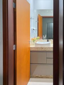 uma casa de banho com um lavatório e um espelho em Ap202 - Residencial Garves em Patos de Minas