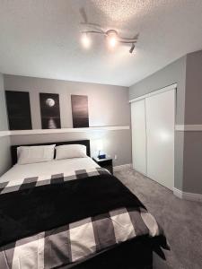 a bedroom with a bed and a ceiling fan at Room in Oshawa, 24/7 Security, Free Parking in Oshawa