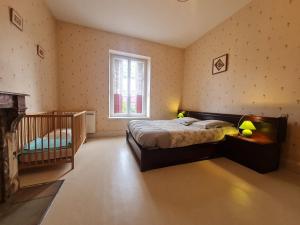 a bedroom with a bed and a crib in it at Gîte familial au bord du Canal de la Marne au Rhin, idéal pour pêche et randonnées, proche de Nancy - FR-1-584-29 in Parroy