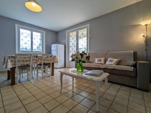 ein Wohnzimmer mit Sofa und Tisch in der Unterkunft Appartement Spacieux avec Jardin Privatif, Proche du Puy-en-Velay et d'un Golf, WiFi Inclus - FR-1-582-286 in Saint-Pierre-Eynac