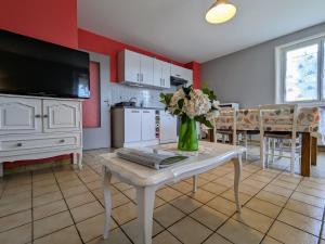eine Küche mit einem Tisch mit einer Vase mit Blumen darauf in der Unterkunft Appartement Spacieux avec Jardin Privatif, Proche du Puy-en-Velay et d'un Golf, WiFi Inclus - FR-1-582-286 in Saint-Pierre-Eynac