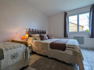 ein Schlafzimmer mit zwei Betten und einem Fenster in der Unterkunft Appartement Spacieux avec Jardin Privatif, Proche du Puy-en-Velay et d'un Golf, WiFi Inclus - FR-1-582-286 in Saint-Pierre-Eynac