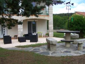 einem Picknicktisch und Bänken vor einem Gebäude in der Unterkunft Appartement Spacieux avec Jardin Privatif, Proche du Puy-en-Velay et d'un Golf, WiFi Inclus - FR-1-582-286 in Saint-Pierre-Eynac