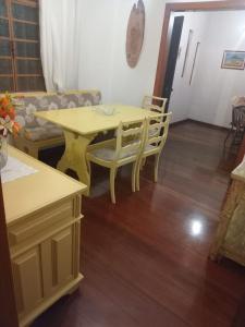 a yellow table and chairs in a living room at Refúgio Girassol in Campos do Jordão