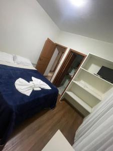 a bedroom with a blue bed and an open cabinet at Refúgio Girassol in Campos do Jordão