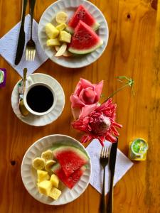 - une table avec des assiettes de fruits et une tasse de café dans l'établissement Coffee House Minca, à Minca