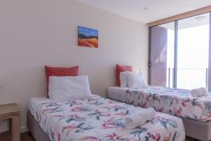 a bedroom with two beds and a window at Strand Beachside 903 in Forster
