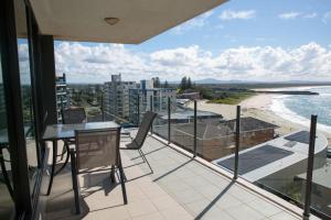 a balcony with a table and chairs and a view of a beach at Strand Beachside 903 in Forster
