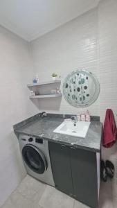 a bathroom with a washing machine and a sink at Tadrart house - Joli Appartement à Agadir in Agadir