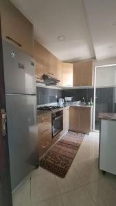 a kitchen with a stainless steel refrigerator and stove at Tadrart house - Joli Appartement à Agadir in Agadir