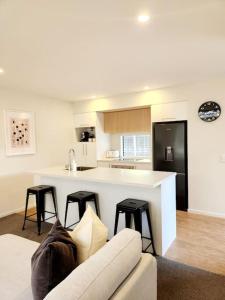 Una sala de estar con un sofá y una cocina. en Central Home with Internal Garage - Close to CBD!, en Christchurch
