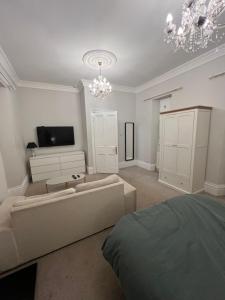 a living room with a couch and a flat screen tv at Dundee Beds in Dundee