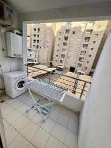 a laundry room with a washing machine and a window at Superbe appartement salon deux grandes chambres à coucher in Al Karm +1 photo