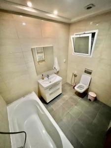 a bathroom with a tub and a sink and a toilet at Superbe appartement salon deux grandes chambres à coucher in Al Karm