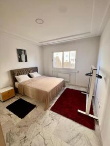 a bedroom with a large bed and a red rug at Superbe appartement salon deux grandes chambres à coucher in Al Karm