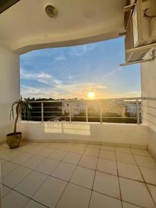 a balcony with a view of the sunset on a building at Superbe appartement salon deux grandes chambres à coucher in Al Karm