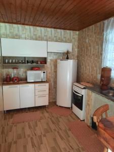 卡曼杜卡亞的住宿－Sítio jaguary，厨房配有白色冰箱和炉灶。
