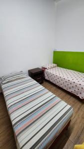 Habitación con 2 camas individuales y mesa. en Departamentos Fueguinos en Ushuaia