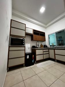 eine Küche mit einer Spüle und einer Mikrowelle in der Unterkunft Apartamento em Cuiabá na Fernando Corrêa in Cuiabá