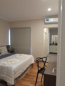 um quarto com uma cama e uma cadeira em Hotel Azul Junin em Junín