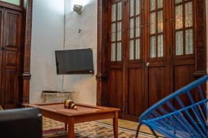 a living room with a table and a tv at Casa Armadillo, colonial house with pool in Mérida