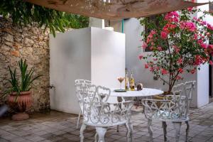 a table and chairs on a patio with flowers at Casa Armadillo, colonial house with pool in Mérida