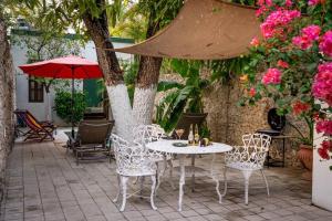 a patio with a table and chairs and an umbrella at Casa Armadillo, colonial house with pool in Mérida