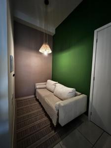 ein Zimmer mit einem Sofa in einer grünen Wand in der Unterkunft Apartamento em Cuiabá na Fernando Corrêa in Cuiabá