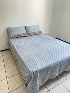 a bed with a blue comforter and pillows on it at Ap no Derby com Garagem in Sobral