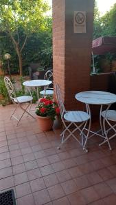 un patio con 2 mesas, sillas y flores en La Quercia Fiorita, en Trivolzio