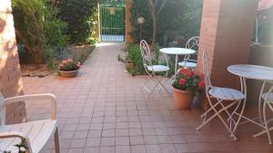 un patio con mesas, sillas y flores en La Quercia Fiorita, en Trivolzio