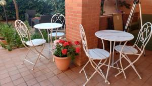 un grupo de mesas, sillas y flores en un patio en La Quercia Fiorita, en Trivolzio