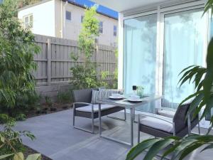 a patio with a table and chairs and a fence at BPM Brighton APT with Garden LG1 in Melbourne