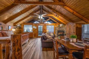 a large living room with a wooden ceiling and a table at Log Cabin, Hot Tub, Fireplace, Pool Table & Views! in Sevierville