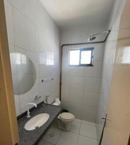 a bathroom with a sink and a toilet and a mirror at Ap no Derby com Garagem AC in Sobral