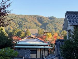 a building with a mountain in the background at Kurodani House in Kyoto