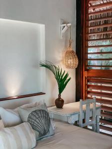 um quarto com uma cama e uma mesa com um vaso de plantas em Pousada Vayú em Icaraí