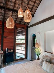 um quarto com luzes pendentes e uma cama em Pousada Vayú em Icaraí