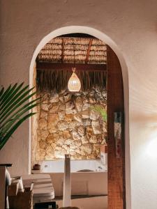 Cette chambre est dotée d'un mur en pierre et d'un lustre. dans l'établissement Pousada Vayú, à Icaraí