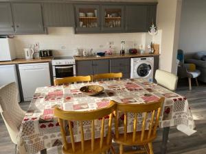 a kitchen with a table with chairs and a table cloth at 35 Atlantic View, Kilkee in Kilkee